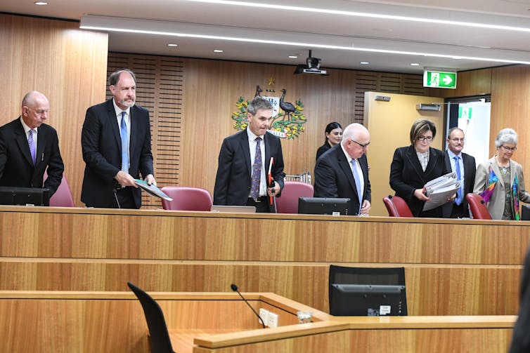 Men and women standing before the tribunal